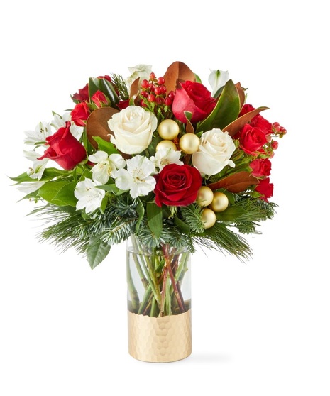 red flowers in tall cylinder vase that is trimmer with gold