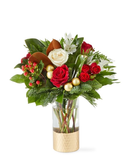 red flowers in tall cylinder vase that is trimmer with gold