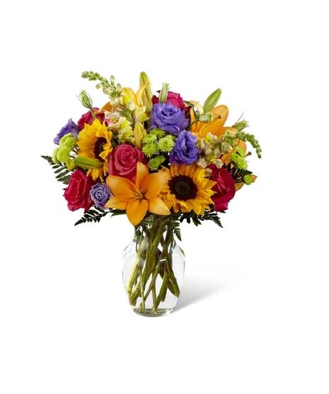 Sunflowers, roses, lilies & greenery in a clear glass vase