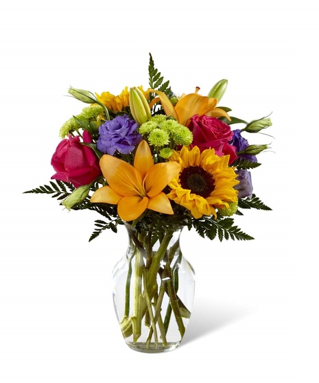 Sunflowers, roses, lilies & greenery in a clear glass vase