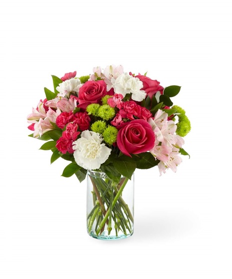 Bright pink roses, pink alstroemeria, white carnations and green mums in a clear glass vase
