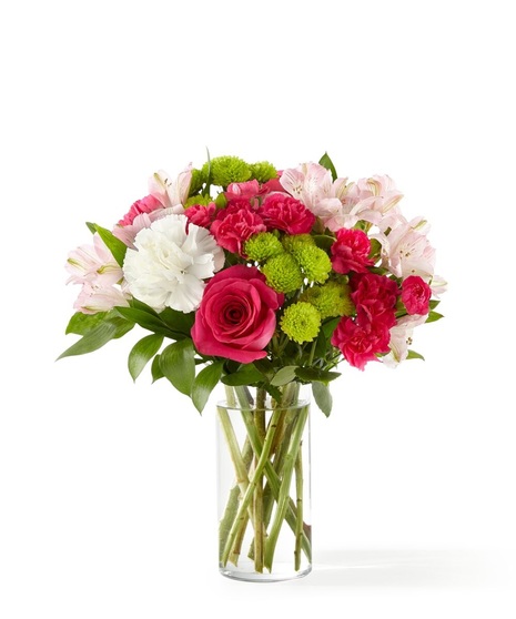 Bright pink roses, pink alstroemeria, white carnations and green mums in a clear glass vase