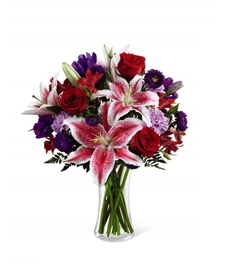 Stargazer lilies, red roses & more in a clear glass vase