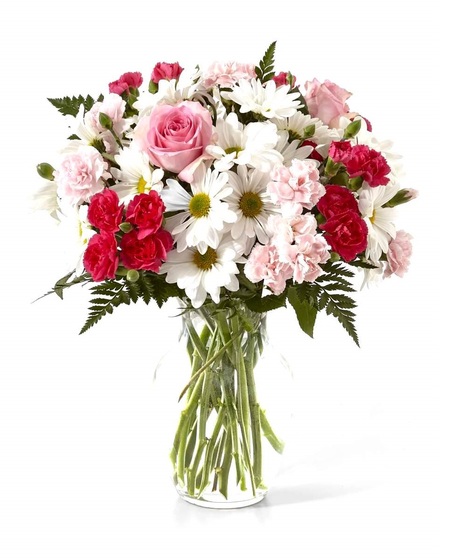 Pink mini carnations along with traditional white daisies and greenery are presented in a classic clear vase.