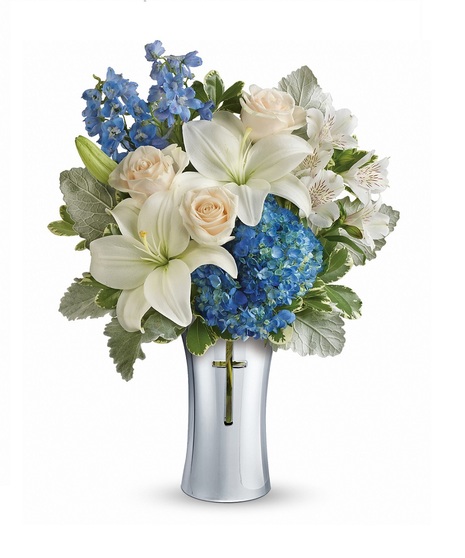 Funeral arrangement of white flowers and greenery in an elegant basket.