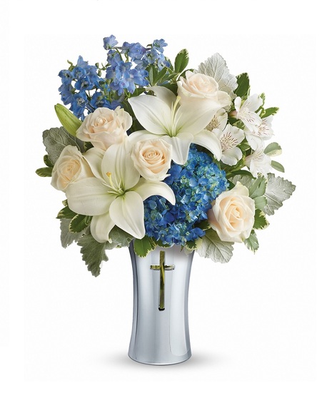 Funeral arrangement of white flowers and greenery in an elegant basket.