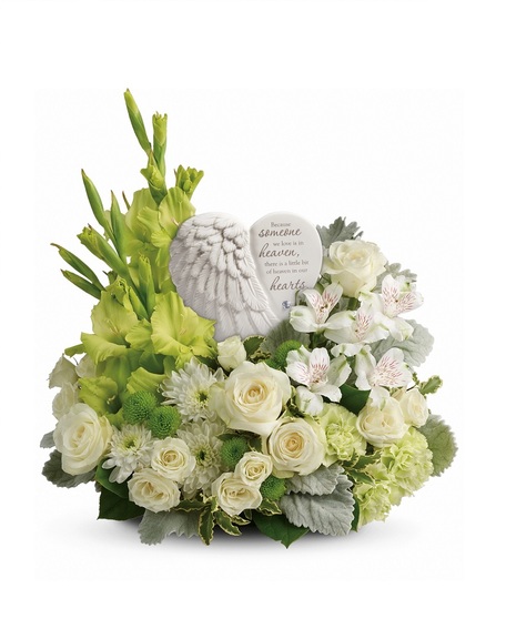 Funeral arrangement of white flowers and greenery in an elegant basket.