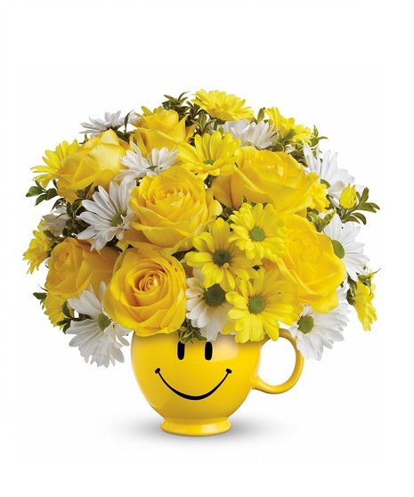 Daisies and roses presented in a yellow smiley face mug