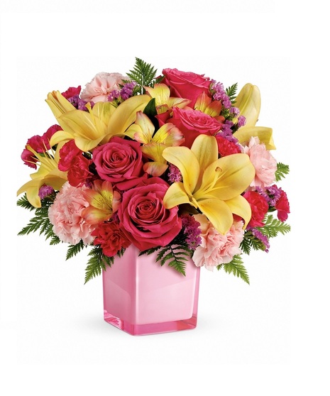 Pink cube vase filled with lilies, roses, carnations and more