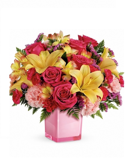 Pink cube vase filled with lilies, roses, carnations and more