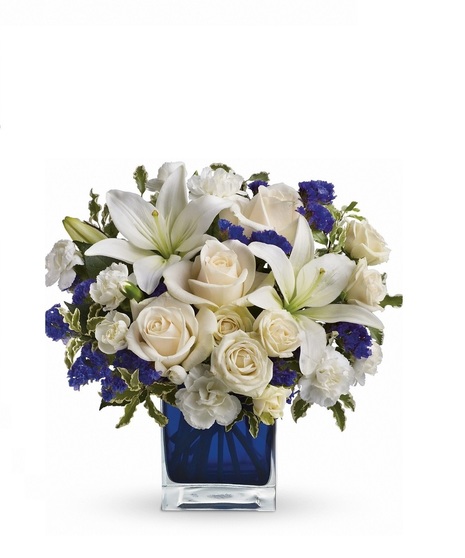 White roses and lilies in a sapphire blue cube vase.