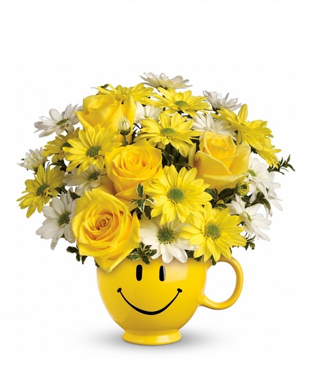 Daisies and roses presented in a yellow smiley face mug